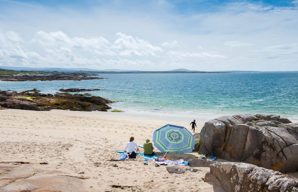 A group of people on Gurteen Beach, Galway on a sunny day