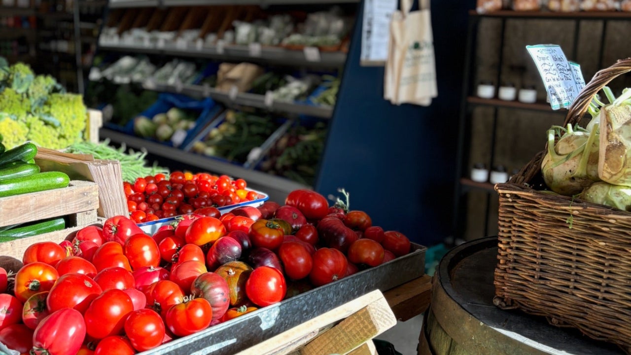 Tomatoes and green vegetables on display in a Farm Shop