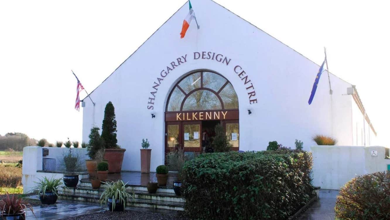 White building with an arched entrance and landscaped gardens