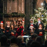 A choir in Christmas hats singing in a church