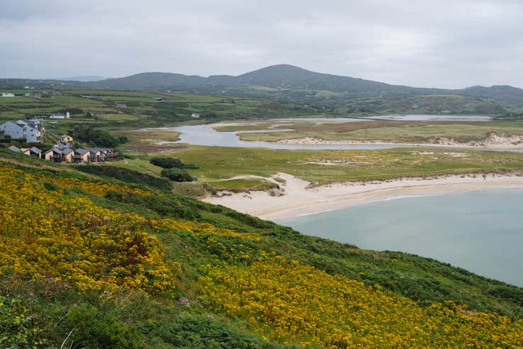 A view of Barley Cove Beach in Cork, with mountains in the background