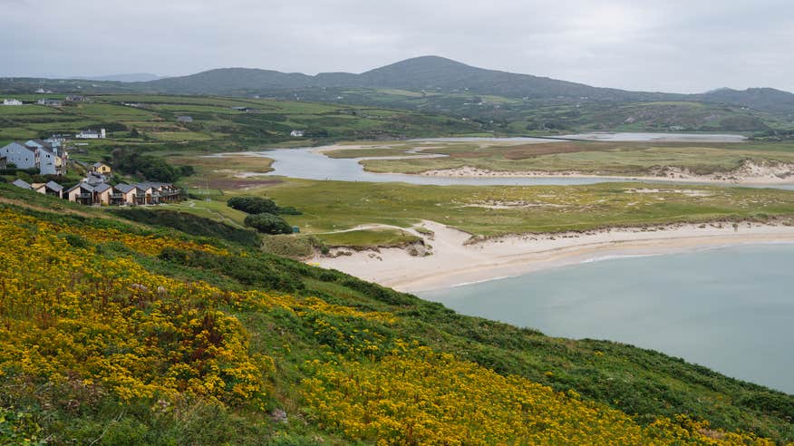 A view of Barley Cove Beach in Cork, with mountains in the background