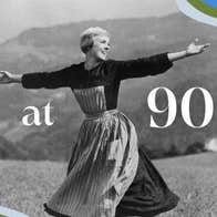Black and white old photo of woman with short hair, wearing an apron, swinging arms out in a field.