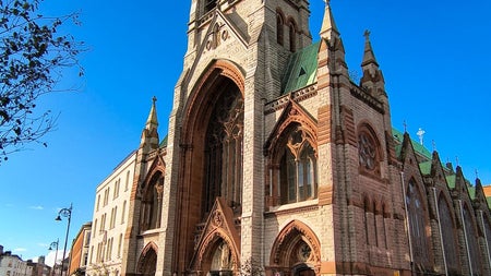 The exterior of a large church featuring a tall tower