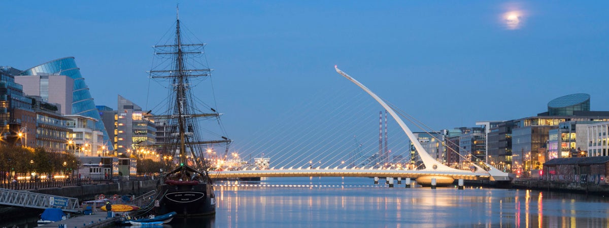The Samuel Beckett Bridge at night with the Jeanie Johnston tall ship in the foreground