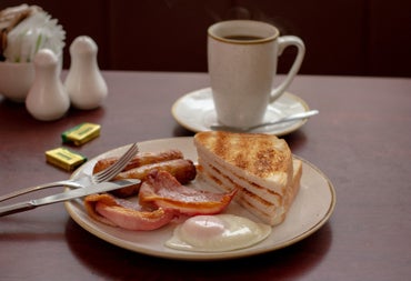 Plate with toast and a fry on it and a large white mug in the background