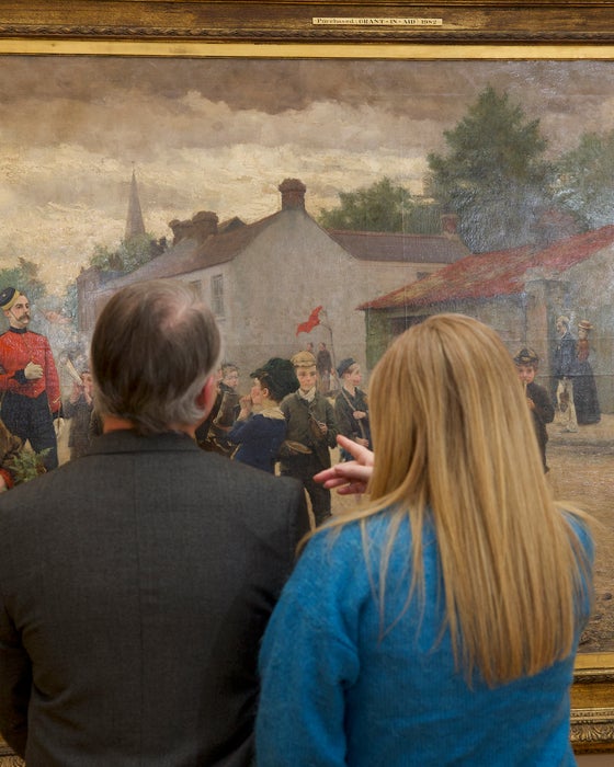 People looking at a painting in the National Gallery of Ireland in Dublin city