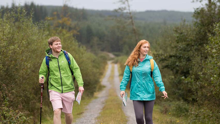 A man and a woman walking along a country road