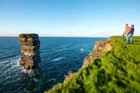 Two people looking out to the sea and sea stack with Rachel's irish Adventure, Downpatrick Head, Mayo