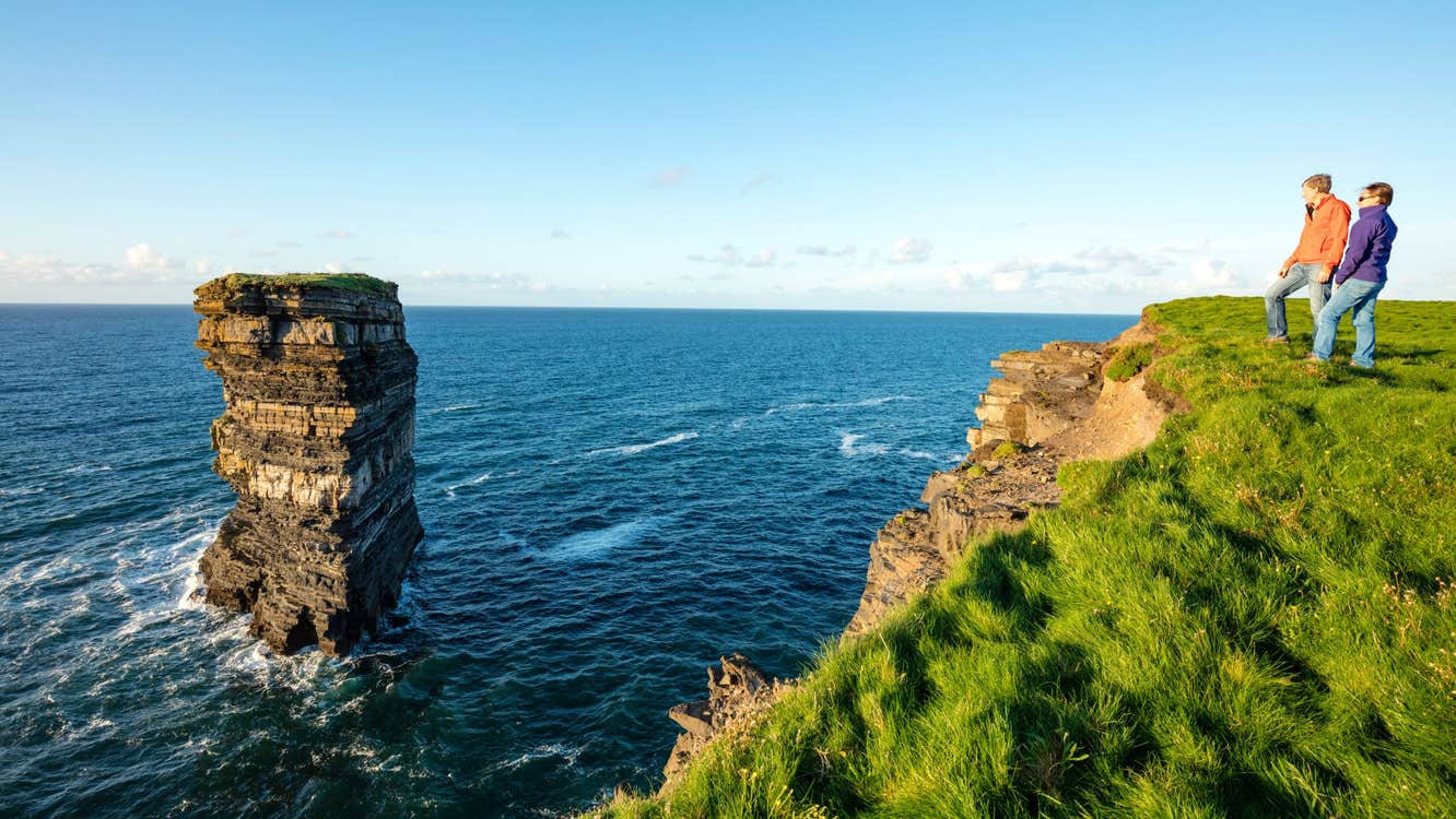 Two people looking out to the sea and sea stack with Rachel's irish Adventure, Downpatrick Head, Mayo