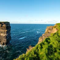 Two people looking out to the sea and sea stack with Rachel's irish Adventure, Downpatrick Head, Mayo