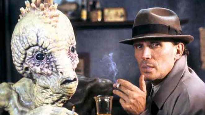 A man is smoking with a calm expression on his face. He is next to a monstrous creature.