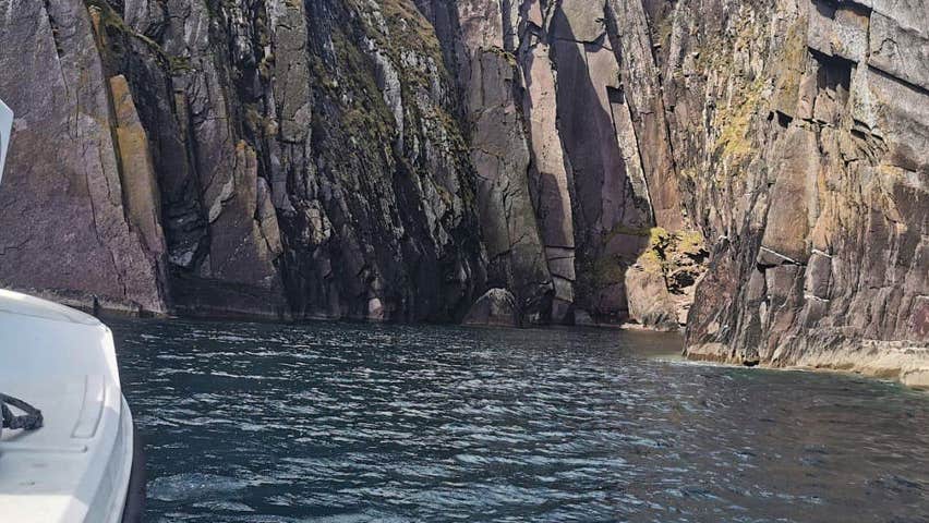 Side of boat facing sea cliffs