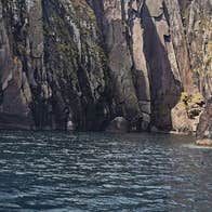 Side of boat facing sea cliffs