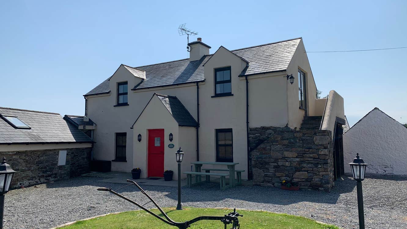 Farmhouse with gravel driveway.