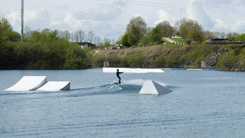 Someone wake boarding on a lake
