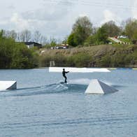 Someone wake boarding on a lake