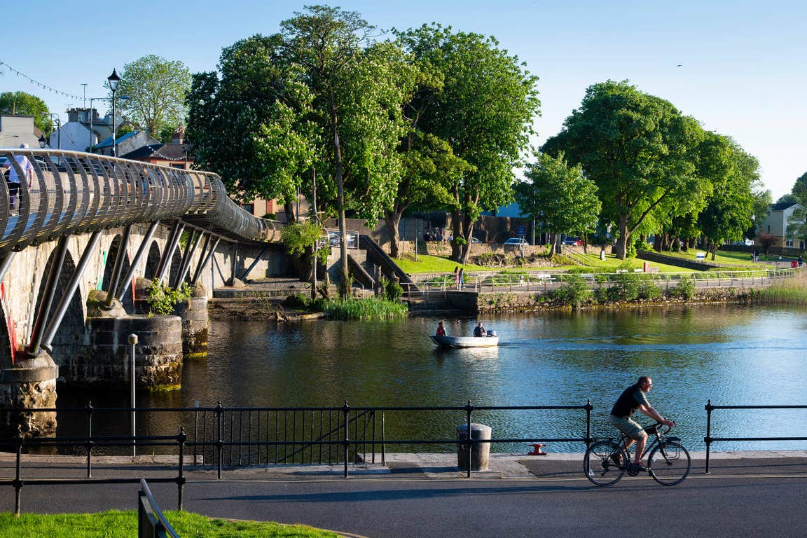 A man cycling on the banks of a river in Carrick-on-Shannon in County Leitrim