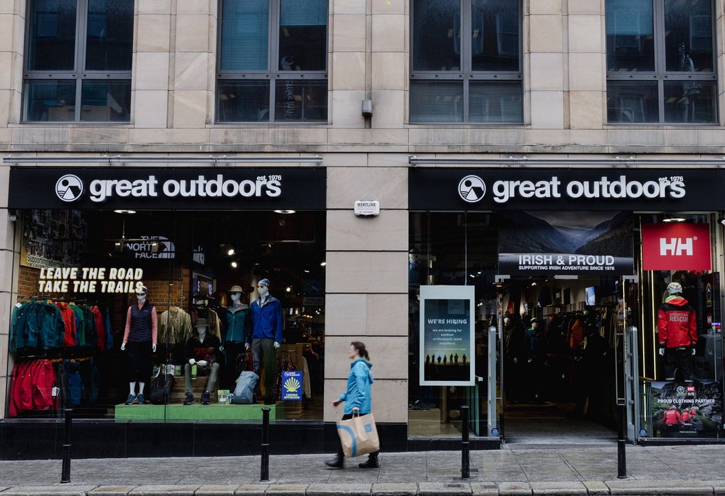 Shop front of a cream coloured building with black awning above the window and doors