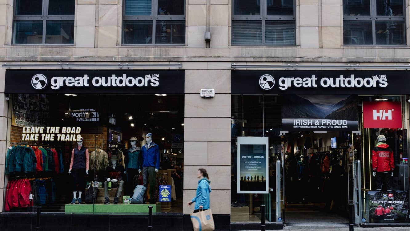 Shop front of a cream coloured building with black awning above the window and doors