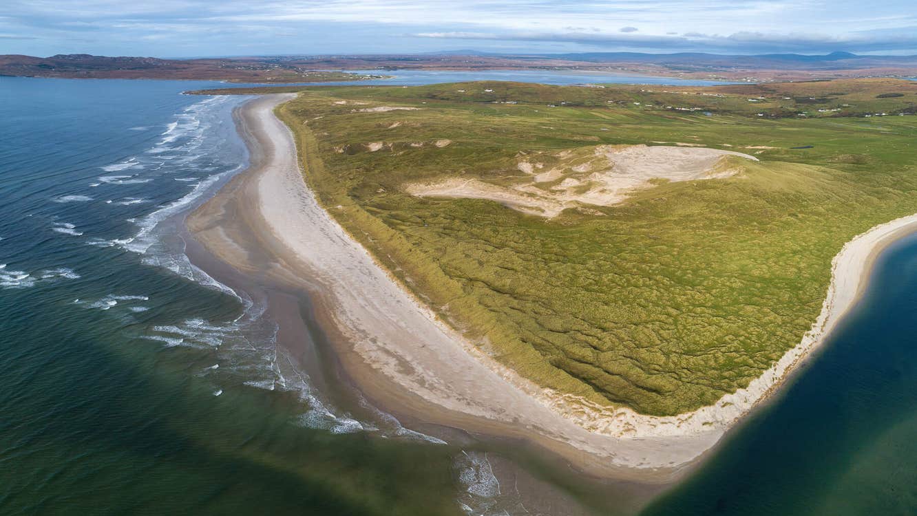 Aeriel view of dunes surrounded by beach and sea