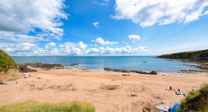 People sitting on the beach at Baginbun Bay in Co Wexford