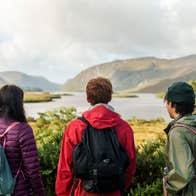 Three people looking out over the loughs at Glenveagh National Park in Letterkenny, County Donegal.