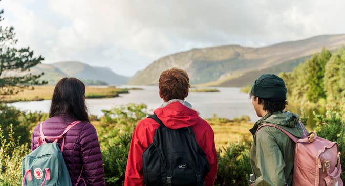 Three people looking out over the loughs at Glenveagh National Park in Letterkenny, County Donegal.