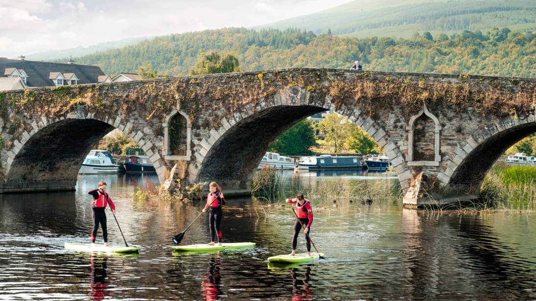 Three people paddle boarding along the River Barrow in Graiguenamanagh, Kilkenny.