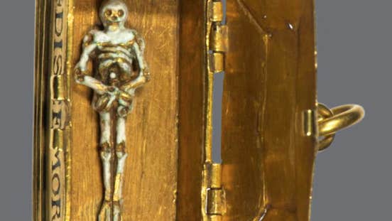 Shadows of Samhain Halloween. A small figure of a skeleton in an old gold box.