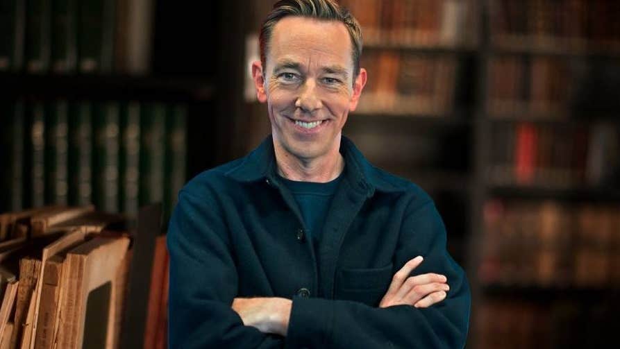 A smiling man with crossed arms