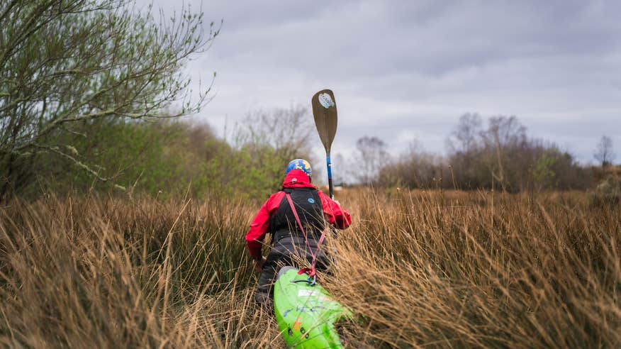 A man kayaking through the brush in the River Shannon