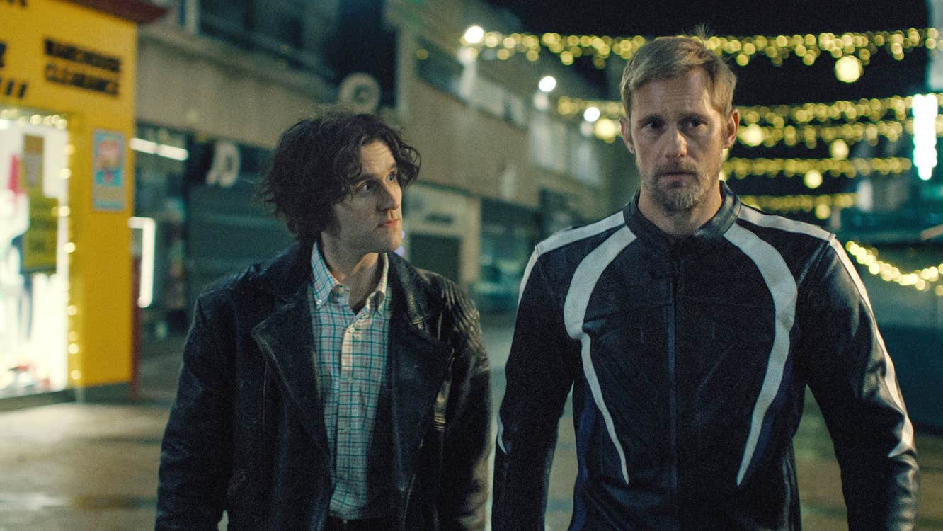 A man is walking along with another man following behind him.