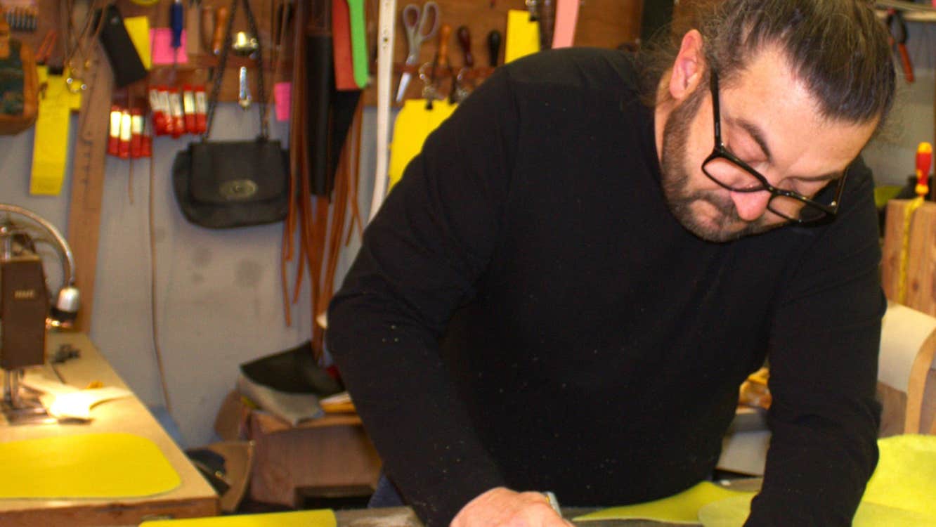 A man at a desk in a studio working on a design