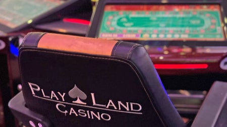 Playland Casino showing a comfortable chair in front of a gaming table