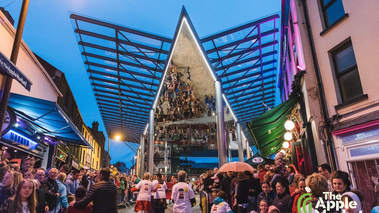 The Apple Market Sessions, outdoor area with large reflective canopy with crowds of people standing around.