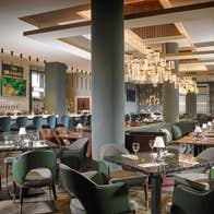 An empty restaurant and bar with dining tables prepared for diners