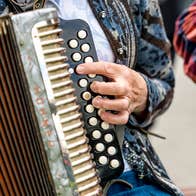 Close up view of person holding an accordion.