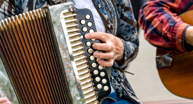 Close up view of person holding an accordion.