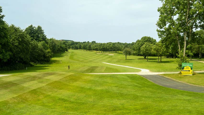 A view of some of the fairways of the golf course with trees to the left and right of the picture