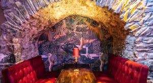 View of a table under an archway with two red cushioned covered seats