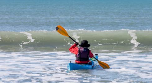 A man kayaking at Garrylucas White Strand beach