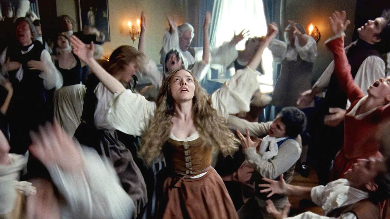 People in 18th Century clothing are dancing wildly.