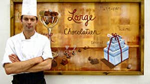 Benoit Lorge standing in front of a Lorge Chocolatier poster in County Kerry.