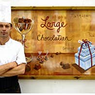 Benoit Lorge standing in front of a Lorge Chocolatier poster in County Kerry.