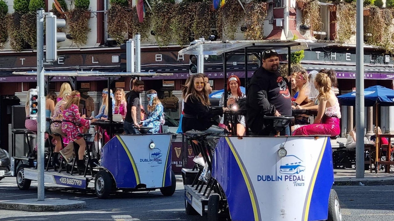 A group riding two Dublin Pedal Tours bikes through a busy city street