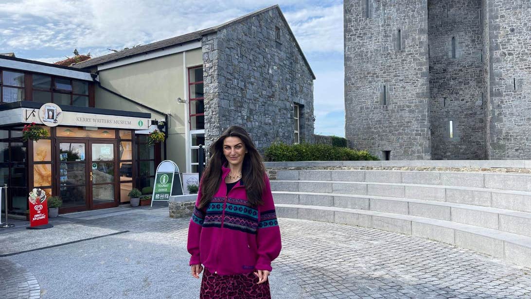 Woman standing outside the Kerry Writers' Museum in a purple sweater.
