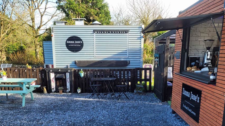 Exterior of a coffee hut and food truck with a picnic table outside