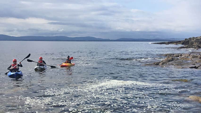 Lake and Coastal Kayak Adventures view of three kayakers on the coast