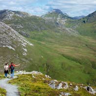 Couple walking with mountains facing them